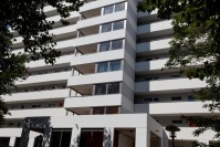 Ausschnitt Aufzugsturm mit Teilverglasung und weiß-grau gestreifter Fassade
