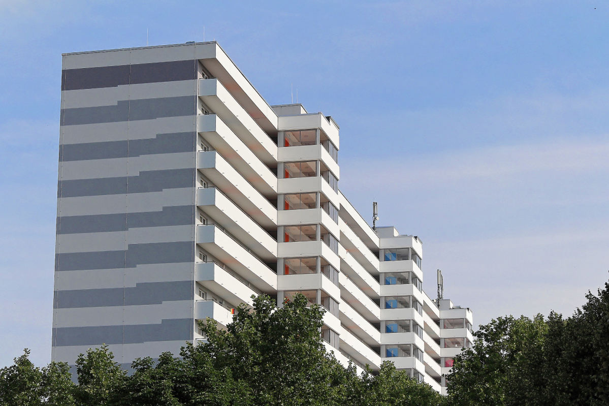 Hochhaus mit weiß-grau gestreifter Fassade und Aufzugstürmen von der Seite Hochhaus mit weiß-grau gestreifter Fassade und Aufzugstürmen von der Seite