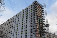 Hochhaus 15 Etagen, 140 Meter lang, rechte Seite saniert, weiße Fassade, Gerüst an Giebel