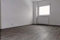 Wohnraum mit Blick auf Fenster. Der Vinylbodenbelag ist im Farbton Eiche gekalkt gehalten.