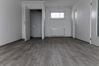 Wohnzimmer mit Blick zum Flur. Der Vinylbodenbelag ist im Farbton Eiche gekalkt gehalten.