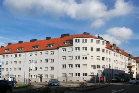 Halbrundes Wohnhaus mit fünf Etagen an befahrener Straße-. Helle Fassade. Halbrundes Wohnhaus mit fünf Etagen an befahrener Straße-. Helle Fassade.