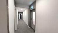 Etagenflur mit grauen Boden und weißen Wänden