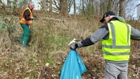 Zwei Mitarbeiter beim Müllsammeln an der Böschung Danziger Straße.