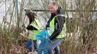 Zwei Personen beim Müllsammeln in der Böschung Danziger Straße.